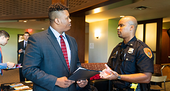 An image of student in conversation with law enforcement officer.