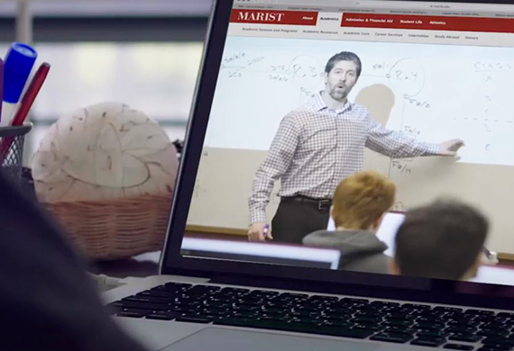 An image of a class being held online and in the classroom. 