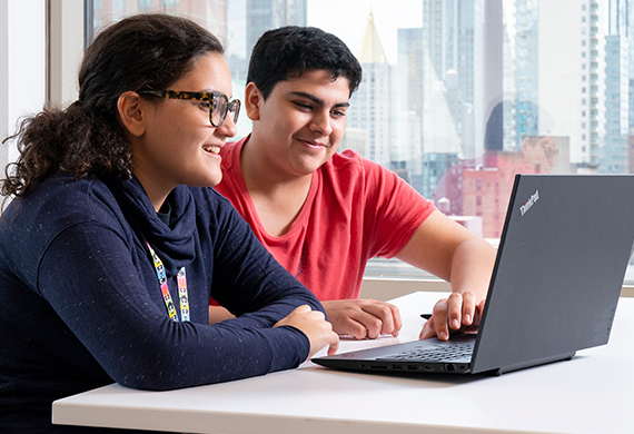 An image of students looking at a computer.