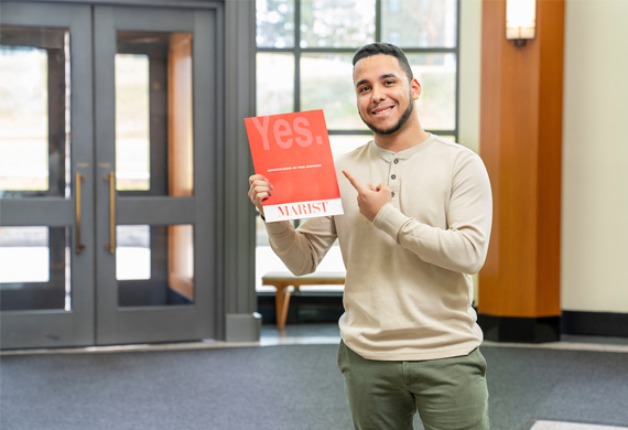 An image of student holding acceptance packet.