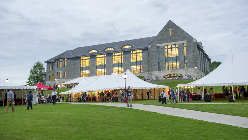 Image of people in tents on the Campus Green outside the library.