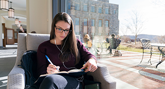 Image of Marist University student sitting outside Hancock.
