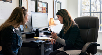 Image of a faculty member meeting with a student.