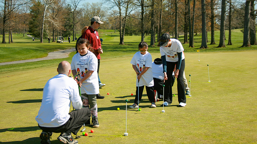 image: DPT students and volunteers coaching children during the adaptive golf clinic. Photo courtesy of Dr. Yvonne Egitto