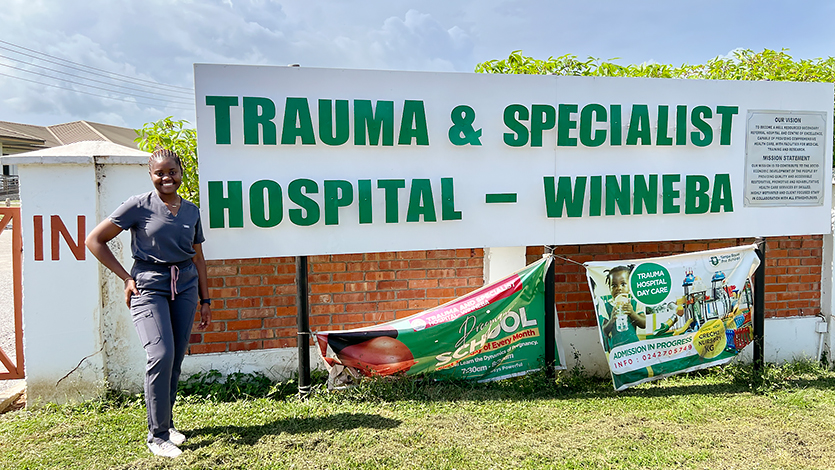 Image of Mbuyi Kalemba standing outside the Trauma and Specialty Hospital in Winneba.