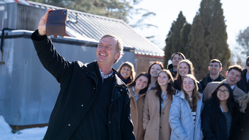 Image of President Weinman taking selfie with students.