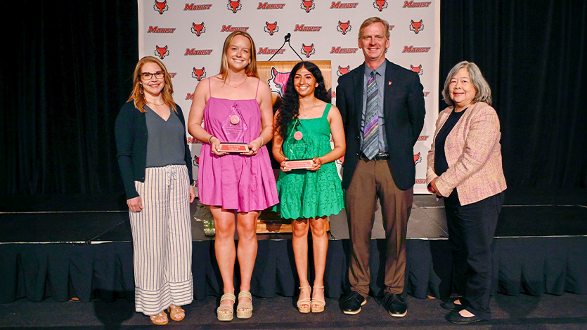 Image of Alyssa Gates, Claire Lewis ‘25, Kiana Pathirana ’25, President Kevin Weinman, and Della Lee Sue in the McCann Center.