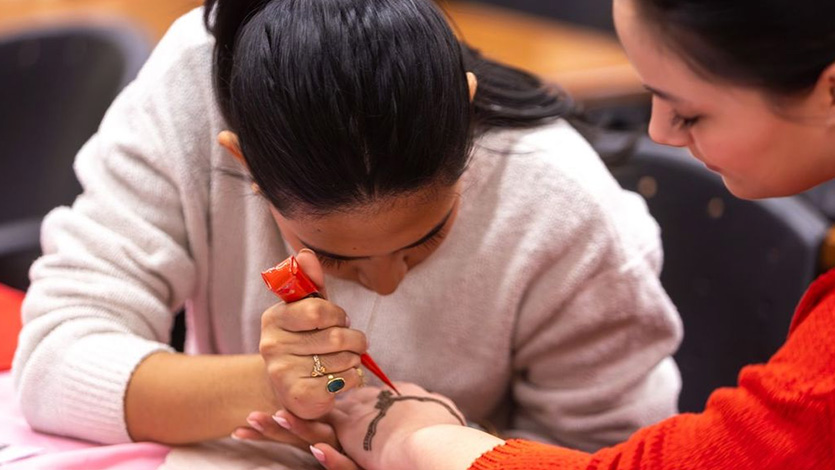 Image of students sharing culture and creativity through the art of henna.