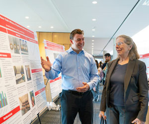 Image of student presenting research to a faculty member.