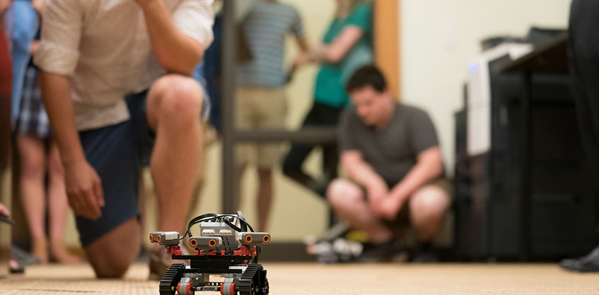 Photo of Student and Robot at Robotics Competition