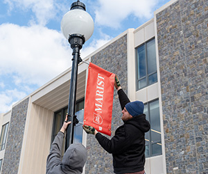 Marist University image: workers install new Marist Univeristy banner.