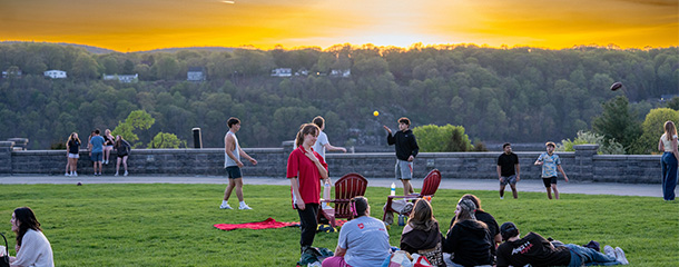 Marist University image: students picnic on the campus green at sunset.