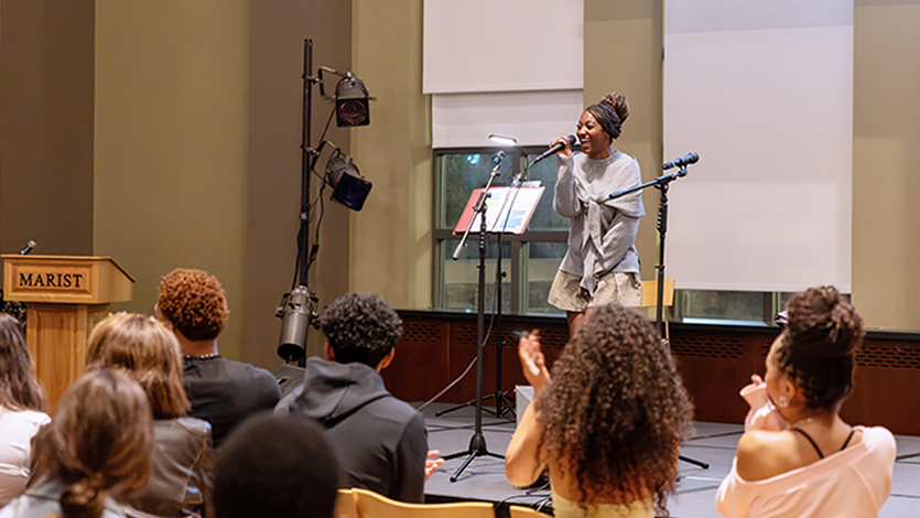 Image of Student volunteer Kayla Jeter '30 leading the September showcase, engaging with audience members and introducing the artists. Photo by Aiden Colby, Forge Media.&nbsp;