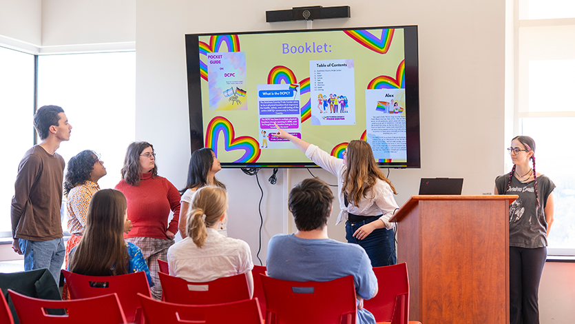 Image of Avery Van Damme ’28 points to her group’s booklet with Erick Johnston ’26, Stella Qadeer ‘28, Laura Rettus ’26, and Lili Bidlo ’26. Photo by Benson Delaney ‘27/Marist University.