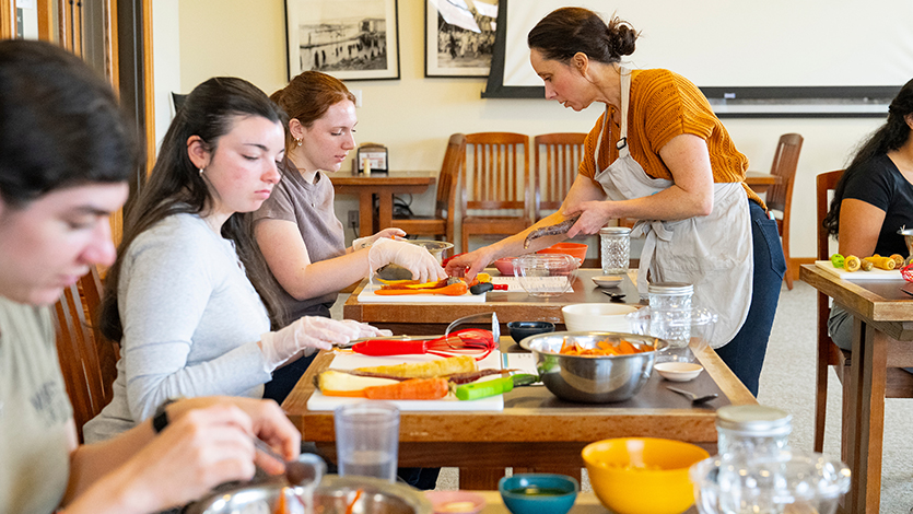 Image of Marie Murphy, Director of Nutrition and Wellness at Marist, provides assistance to students during a Teaching Kitchen. Photo by Carlo de Jesus/Marist University.