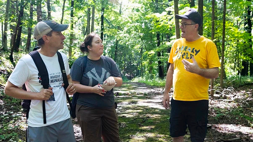 Image of Caitrina&nbsp;Kiel '27&nbsp;(middle)&nbsp;discusses the impact of invasive species with&nbsp;coworkers at&nbsp;Library Field, New Castle, New York.&nbsp;Photo courtesy of&nbsp;Caitrina&nbsp;Kiel '27.&nbsp;&nbsp;