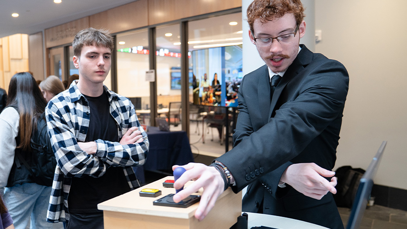 Image of Dan Brogen ’26 demonstrates how to use his game controller to students. Photo by Nelson Echeverria/Marist University.