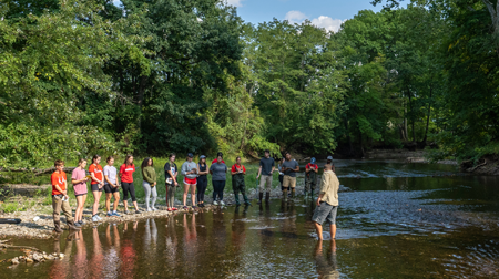 Image of students engaged in experiential learning in a creek.